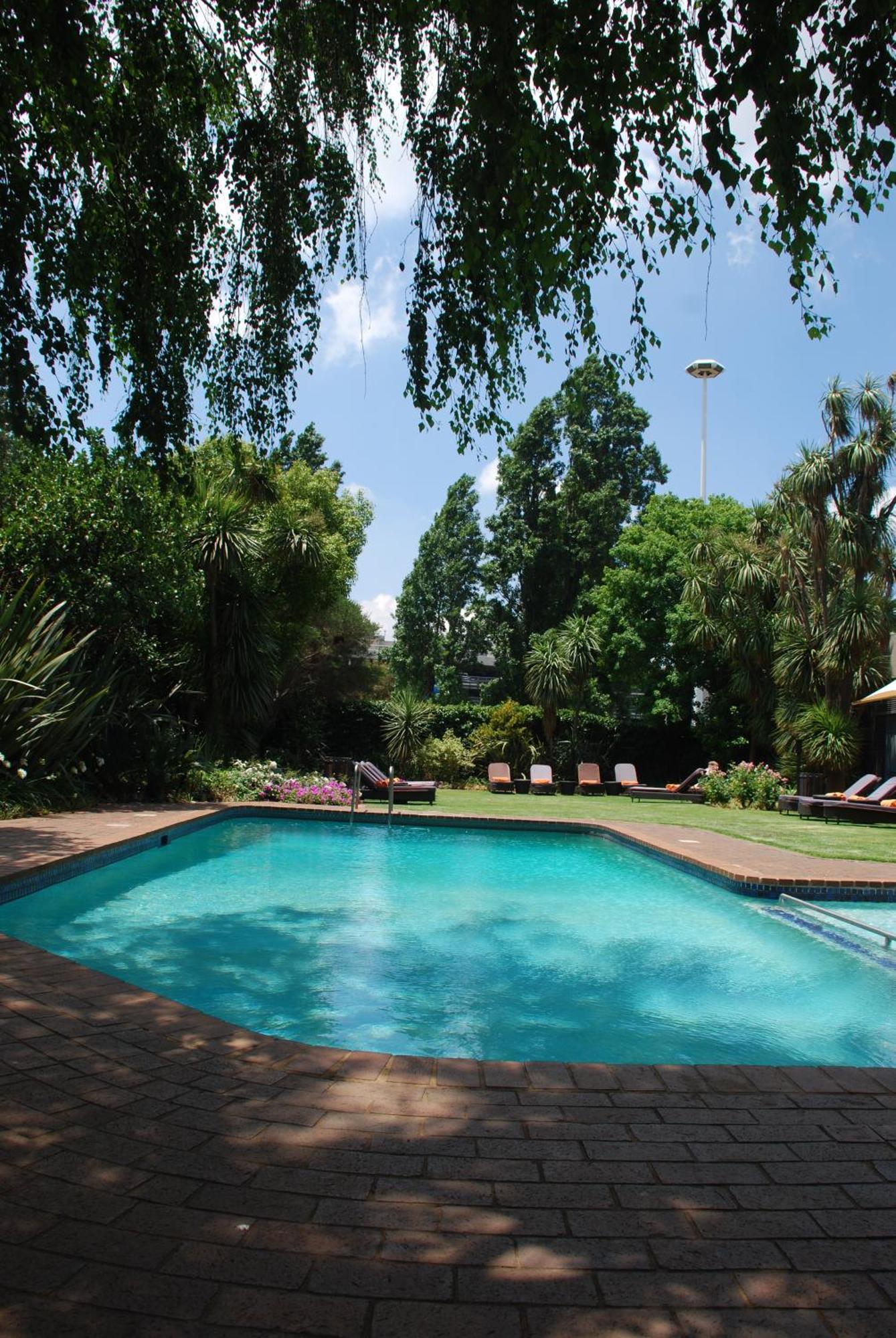 Southern Sun Or Tambo International Airport Kempton Park Dış mekan fotoğraf The garden and swimming pool at the residence